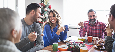 multi generation family enjoying breakfast together in front of Christmas tree