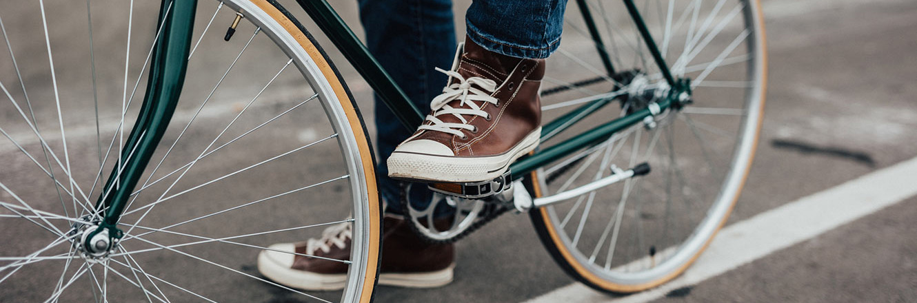 Bike wheels and converse shoes of bike rider