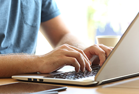 man typing on computer