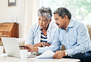 elderly couple looking at laptop