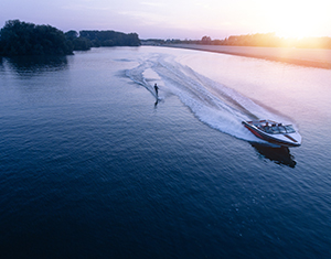 Water skier pulled by speedboat on a clear lake