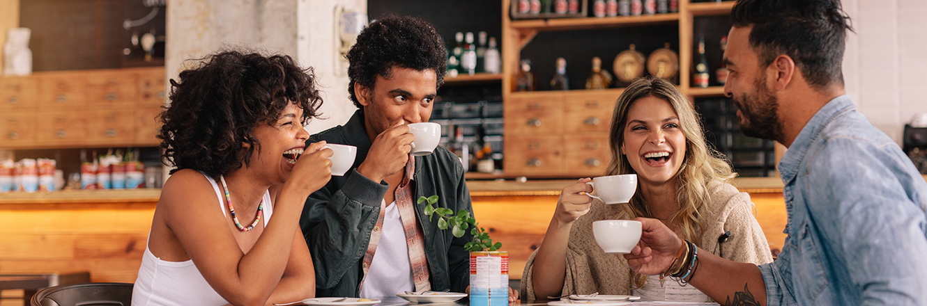 four friends talking and drinking coffee together