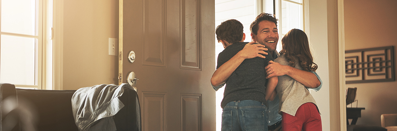 dad hugging children in home