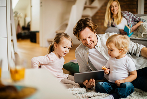 father looking at tablet with children