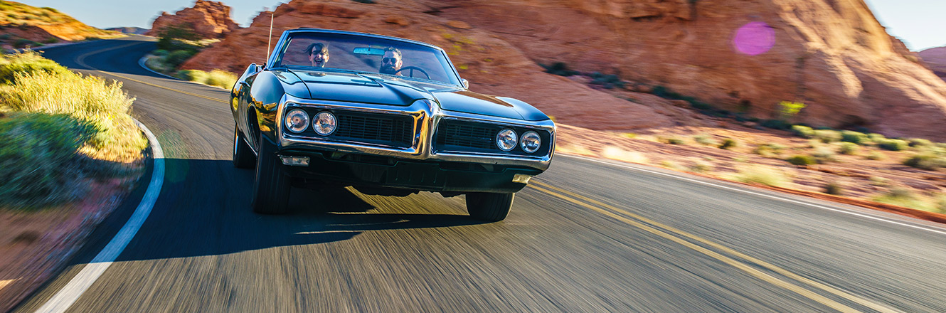 classic car driving in desert