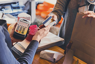 woman using credit or debit card at checkout