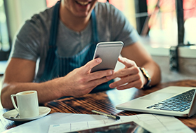 business owner using phone and laptop