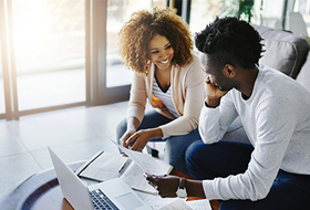 man and woman looking at finances on table