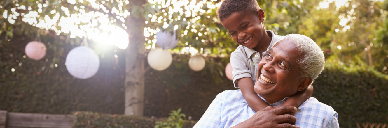 A grandson and grandfather smiling outdoors