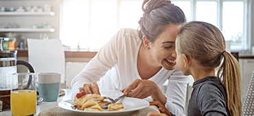 mother and young daughter having breakfast together
