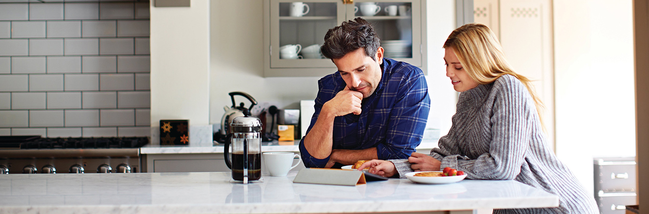 couple looking at tablet in kitchen