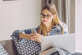 teen girl using phone and laptop