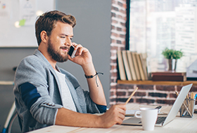 man on laptop and phone