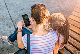 mom and daughter using phone