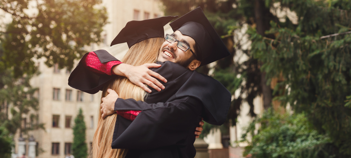 High school friends hugging at graduation