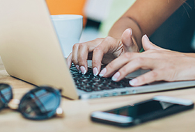 teen typing on laptop