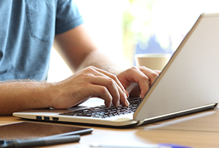 man typing on computer