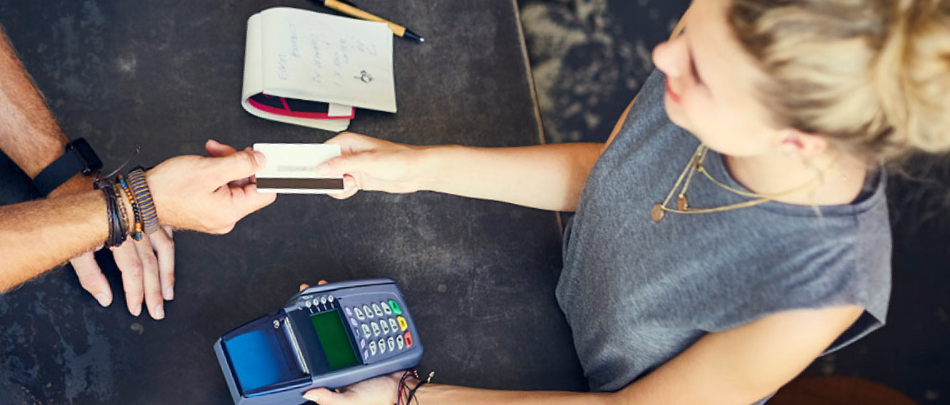 A people paying at a store with a debit/credit card