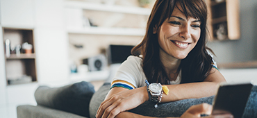 woman sitting on couch holding phone