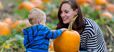 mother and toddler son at pumpkin patch