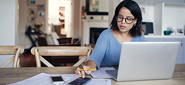 woman typing on laptop in kitchen