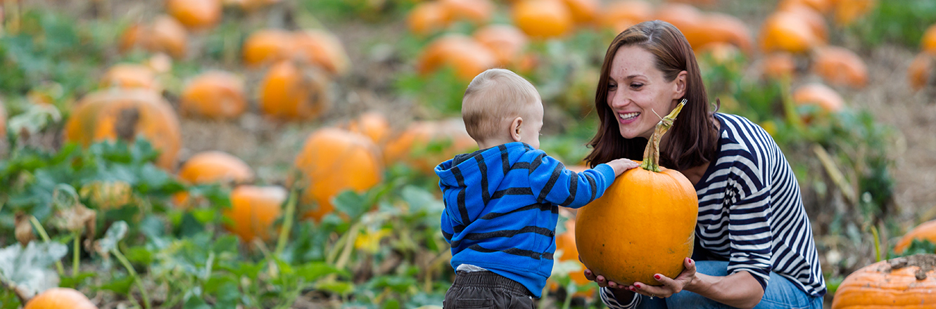 mother and toddler son at pumpkin patch