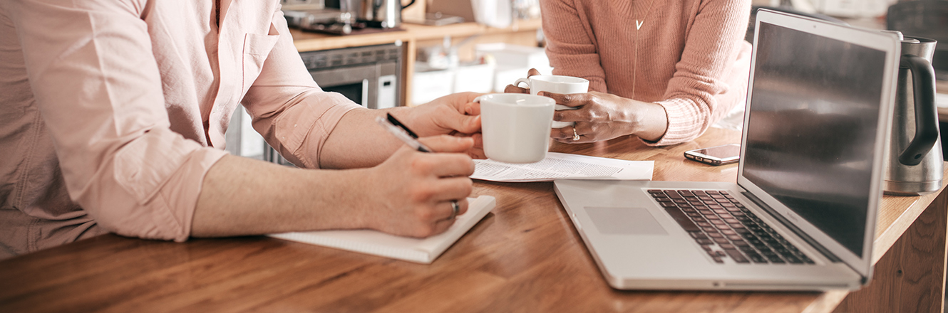 couple sitting in kitchen looking at paperwork