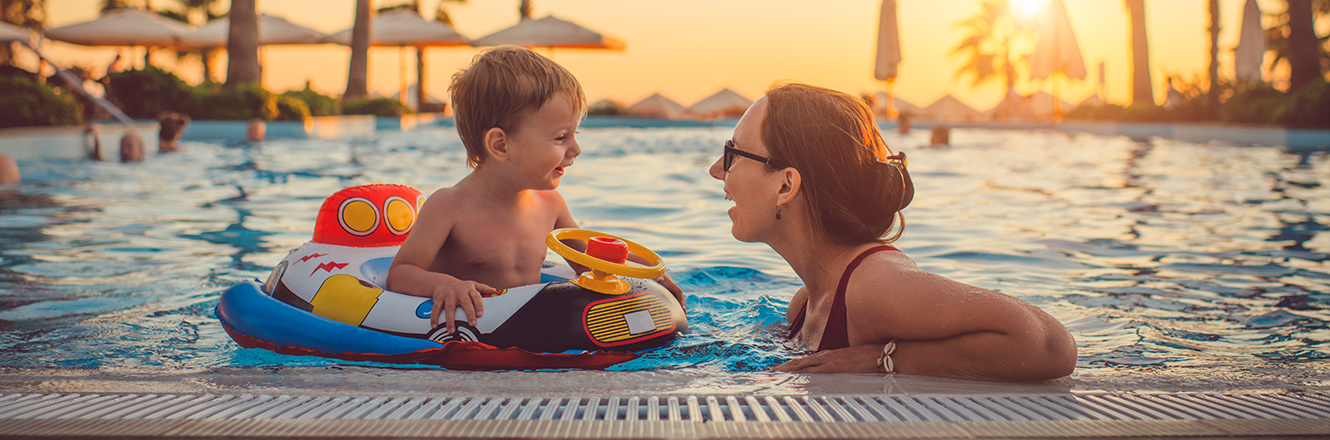 mother and toddler son in pool at resort