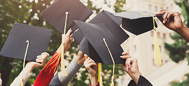 graduates holding caps in the air