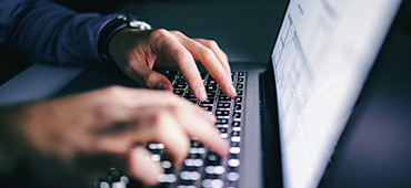 Fingers typing on laptop keyboard