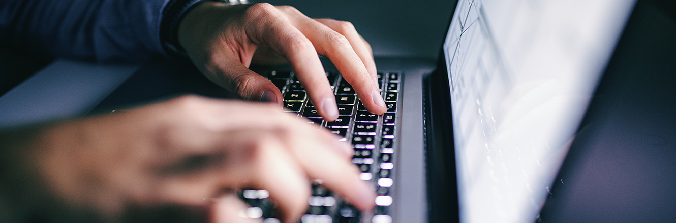 Fingers typing on laptop keyboard