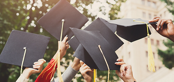 graduates holding caps in the air
